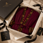 A luxury robe gift set from External Links, featuring a deep burgundy robe with gold and black geometric patterns, presented in an open black box with branded packaging, tissue paper, and a thank you card.