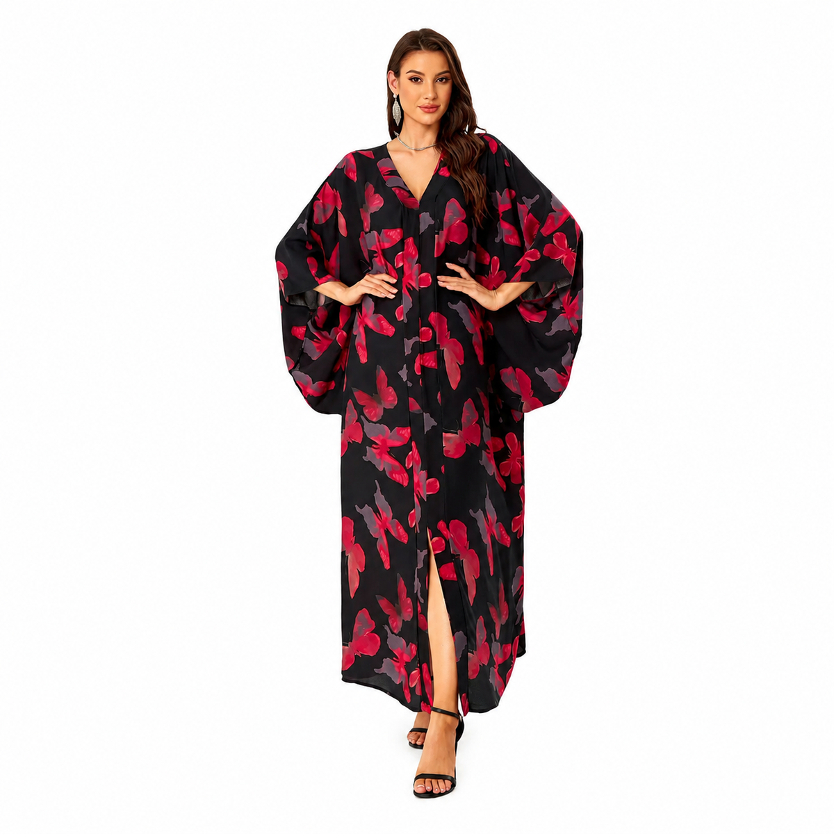 A woman modeling a long black kaftan dress with a red and pink abstract floral pattern, featuring wide balloon sleeves, a V-neckline, and a front slit, set against a plain white background.
