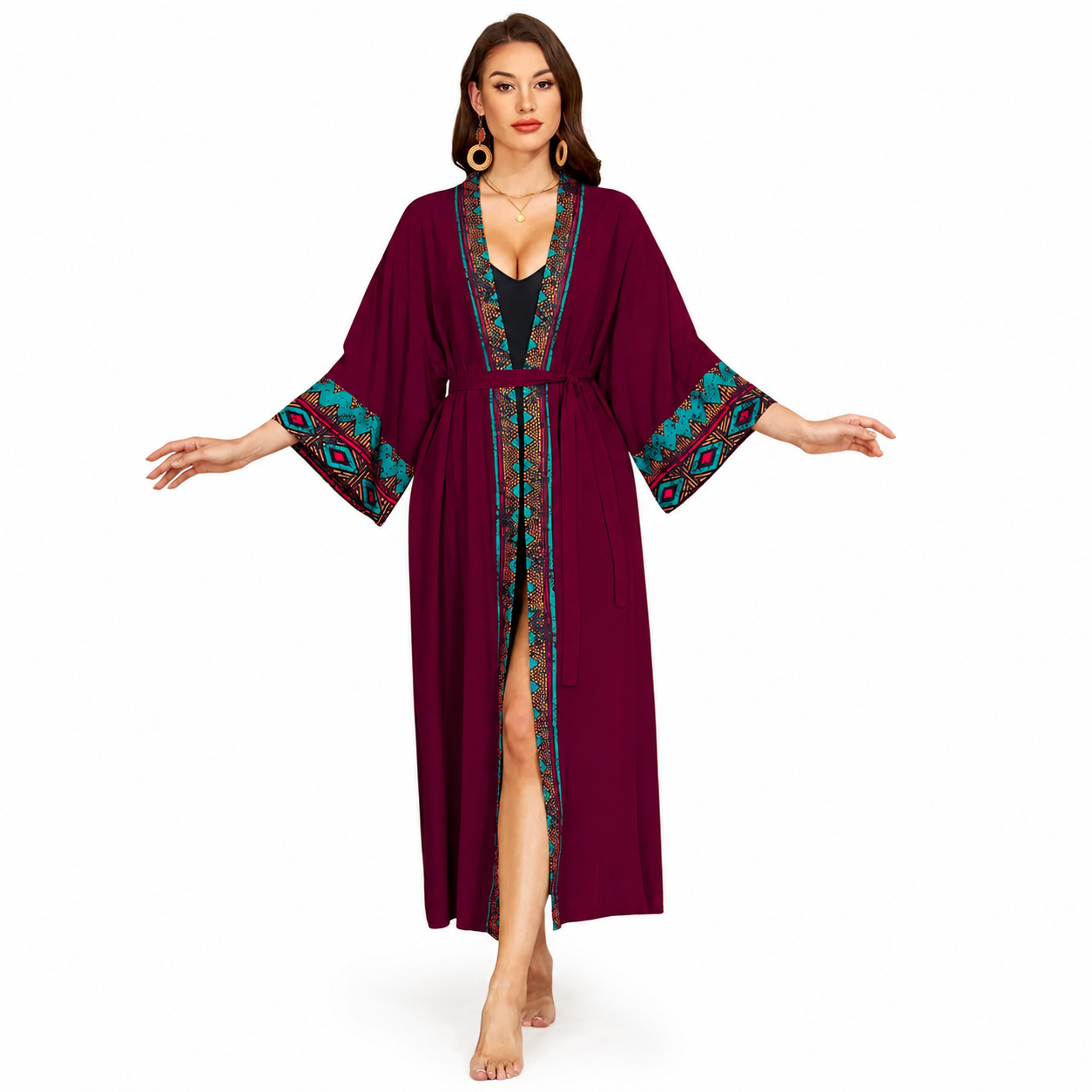 A woman modeling a long burgundy kimono-style robe with teal, red, and gold patterned trim on the collar, front opening, and wide sleeves, shown against a plain white background.