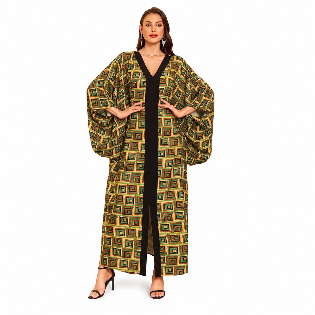 A woman modeling a long, loose kaftan-style robe with a geometric pattern in olive green, gold, and black, worn over a black dress, on a solid white background.