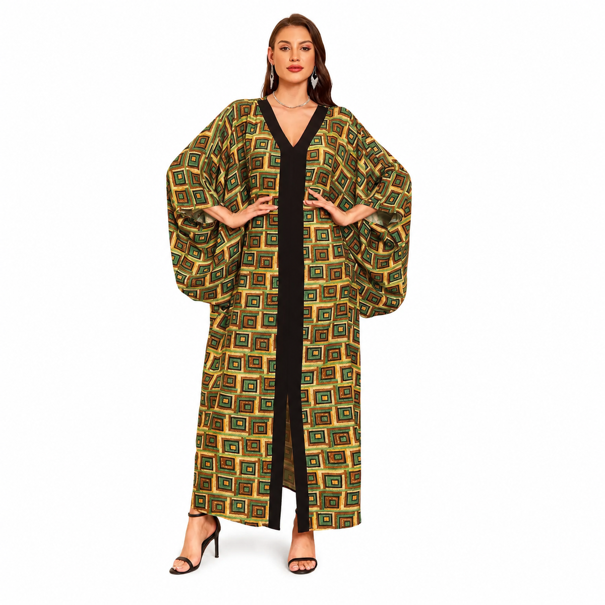 A woman modeling a long, loose kaftan-style robe with a geometric pattern in olive green, gold, and black, worn over a black dress, on a solid white background.