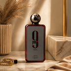 Afnan 9PM Rebel luxury perfume bottle displayed on marble surface with premium editorial styling and elegant accessories.