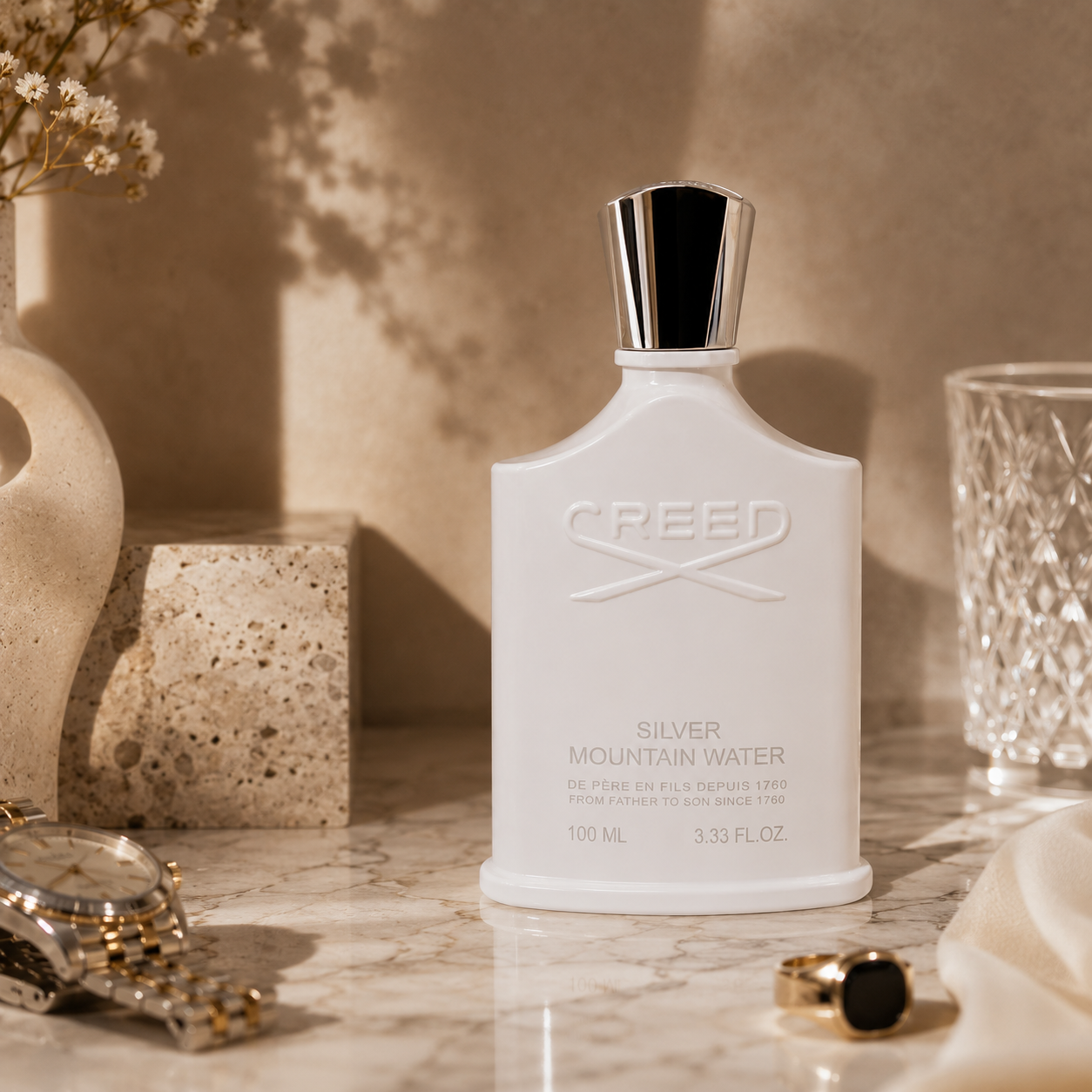 Luxury editorial composition featuring Creed Silver Mountain Water perfume with marble surface and premium accessories