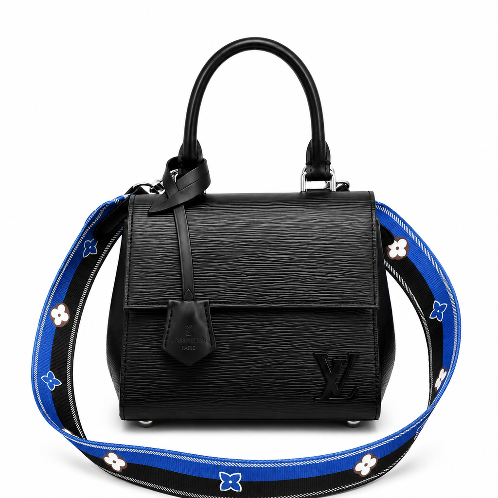 Luxury black textured leather handbag with top handle and blue designer shoulder strap on white background
