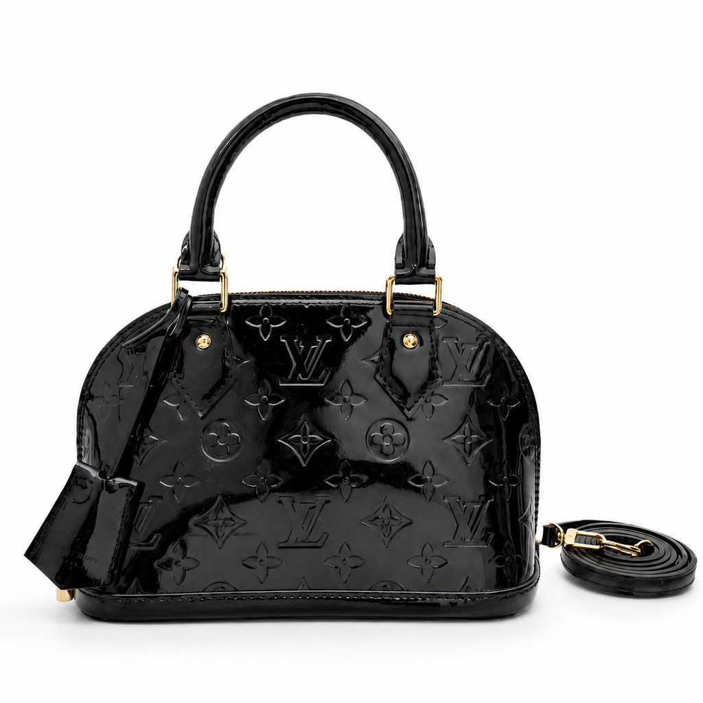 Luxury black patent leather handbag with embossed monogram design and gold hardware on white background.