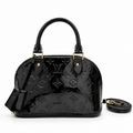 Luxury black patent leather handbag with embossed monogram design and gold hardware on white background.