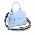 Elegant sky blue luxury women’s handbag with structured top handle and designer shoulder strap on white background.