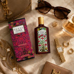 Luxury floral perfume flat lay composition with sunglasses, jewelry, watch, and premium fashion accessories.