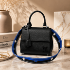Top view flatlay of luxury black handbag with sunglasses, perfume, jewelry, and premium fashion accessories