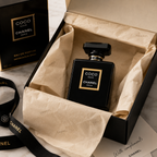Premium black Eau de Parfum presented in an elegant luxury gift box with tissue paper and ribbon, creating a high-end unboxing experience.