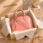 Elegant pink patent leather handbag presented inside luxury packaging box with tissue paper, ribbon, and premium unboxing styling.