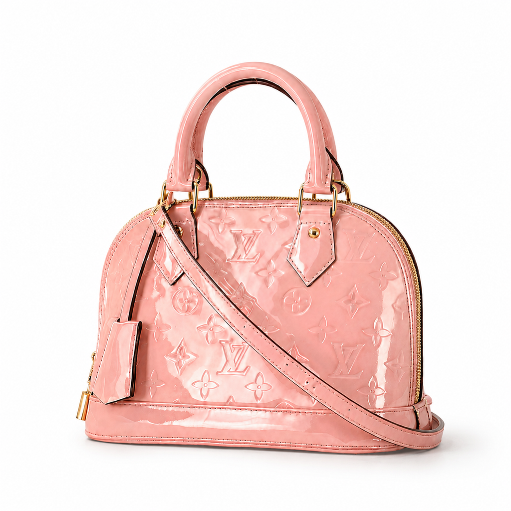Elegant pink patent leather handbag with embossed monogram texture, gold hardware, and structured luxury silhouette on white background.