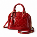 Luxury red patent leather women’s handbag with embossed detailing and gold hardware on white background.