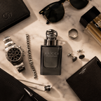 Premium men's perfume arranged with luxury accessories including sunglasses, watch, jewelry, and leather goods in a modern Dubai-inspired flat lay.