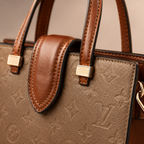 Close-up view of luxury monogram tote bag showing premium texture, fine stitching, and gold-tone hardware