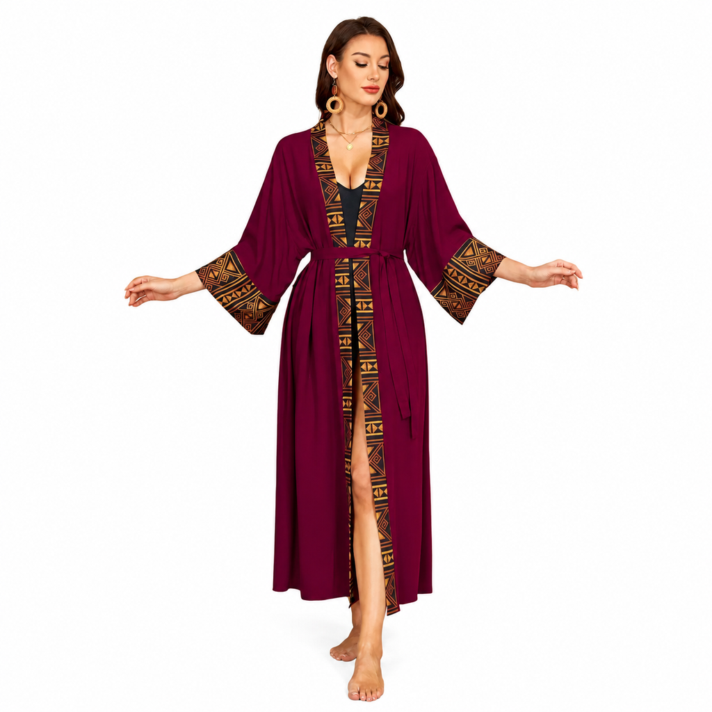 A woman modeling a long, deep burgundy maxi robe with wide sleeves and gold geometric patterned trim along the front opening and cuffs, shown against a plain white background.